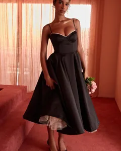 Elegant black spaghetti strap gown featuring a voluminous skirt and white tulle petticoat