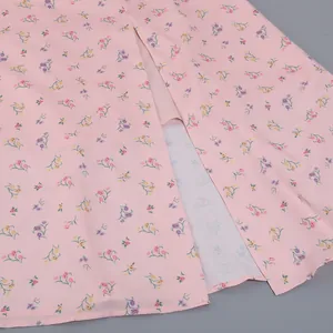 Detailed macro shot of a pink floral French dress featuring a stylish hemline slit.