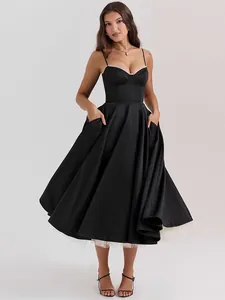 Detailed view of an elegant black spaghetti strap evening dress with a full pleated skirt