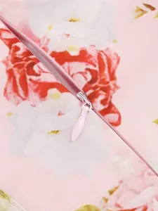 Close-up of a hidden zipper on a pink floral print dress showing fabric texture