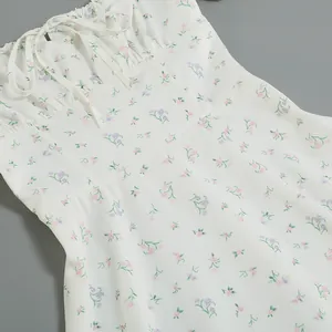 Close-up of French floral vacation dress featuring delicate ruched bust and tie-neck detail