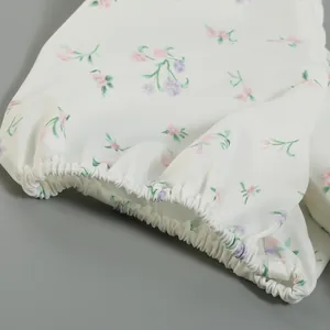 Detailed view of the elastic puff sleeve cuff on a French style white floral dress fabric