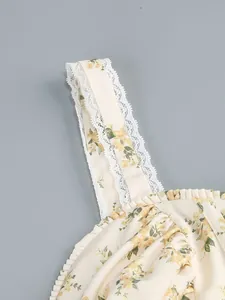 Detail of white floral dress with lace shoulder strap and delicate yellow flower print