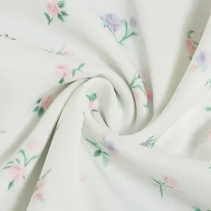 Detailed macro view of white French floral dress fabric with soft pink and purple blossoms