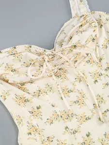 Close-up detail of a cream floral print dress featuring a front tie and delicate lace straps