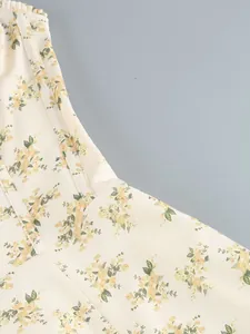 Close-up detail showing the delicate yellow floral print fabric on a cream midi dress
