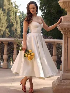 Elegant white satin midi dress with spaghetti straps and voluminous flared skirt