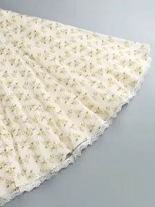Close-up of floral print midi dress featuring elegant white lace trim at the hem