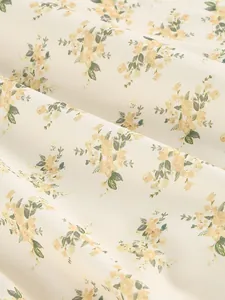 Detailed close-up view of the elegant yellow floral print on soft cream fabric