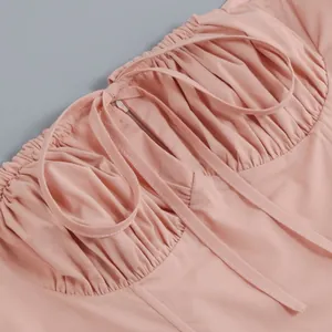 Macro detail view of a pink French style dress featuring ruched bodice and ties