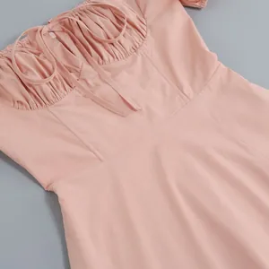 Macro view of French style pink dress showing gathered bust and delicate tie detail