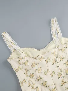 Detailed view of a floral print dress featuring delicate white lace straps and yellow flowers