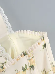 Detail shot showing delicate lace trim and yellow floral print on a summer camisole dress