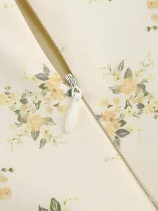 Detailed macro shot of white invisible zipper on elegant floral print dress fabric
