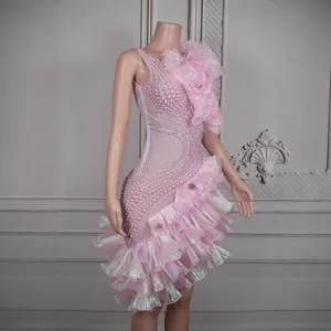 Detailansicht eines pinkfarbenen Bühnenkleids mit Perlenstickerei und gestuften Volants