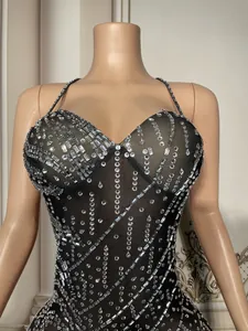 Detalle de vestido negro transparente con pedrería plateada para espectáculos en vivo.