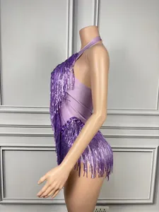 Side view detail of a stylish purple sequined halter bodysuit with long fringe tassels