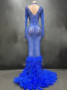 Detalle posterior de vestido de gala azul con pedrería brillante y bajo de plumas tupido