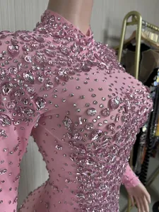 Dettaglio di un abito da sera in rete rosa con scintillanti decorazioni in strass