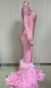 Dettaglio squisito di abito da sera in rete rosa con strass e lussuoso orlo di piume