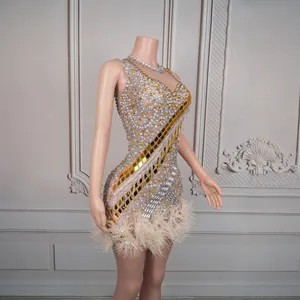 Side view of sparkling rhinestone and gold mirror mini dress with feather trim