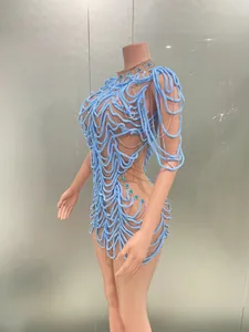 Detailed view of a light blue swirly textured mini dress with silver chains on a mannequin.