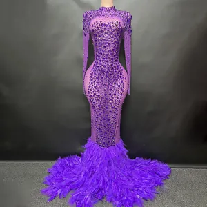 Vestido de noche morado con pedrería brillante y detalle de dobladillo de plumas