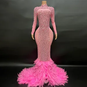 Primer plano de un vestido de noche rosa con diamantes de imitación y plumas elegantes