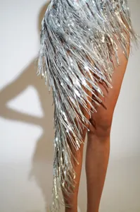 Detailed macro view of shimmering silver tassels on a sparkling performance mini skirt