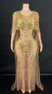 Detailed view of the gold sequin patterns on a nude mesh evening gown with cape.