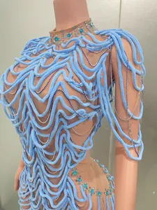 Close-up of light blue designer evening dress with velvet cords and sparkling crystals