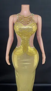 Close-up of the gold evening dress showing side cutouts and intricate rhinestone chain details.