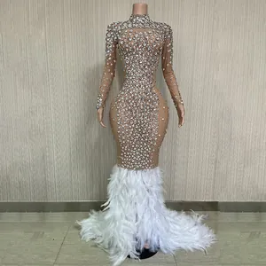 Dettaglio dell'abito da sera di lusso in mesh con strass e orlo a sirena in piuma bianca