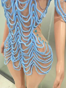 Close-up of blue wave stage costume with silver chains and crystal details for performance.