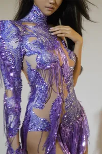 Dettaglio di un mini abito viola con paillettes e frange luccicanti