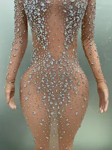 Dettaglio ravvicinato di strass scintillanti su un abito da palcoscenico in mesh color carne.