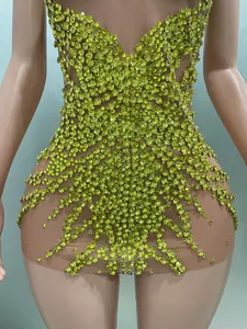 Detailansicht funkelnder limettengrüner Strasssteine auf einem sexy figurbetonten Netzkleid
