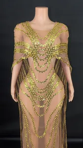 Detail of an elegant V-neck mesh evening gown with gold sequins and cape sleeve design
