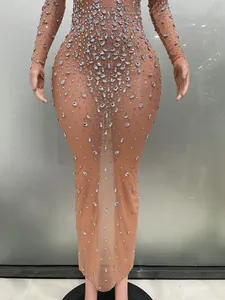 Dettaglio di strass argentati scintillanti su un abito da sera lungo in rete nude.