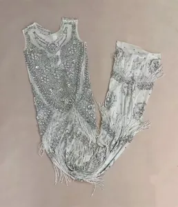Detailed view of a luxury mermaid evening dress with rhinestones and fringe tassels.