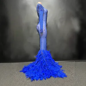 Elegante vestido de noche sirena azul con pedrería brillante y lujosa cola de plumas