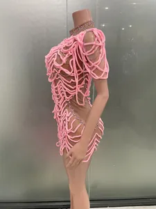 Detail view of unique pink textured evening dress with silver chains on mannequin