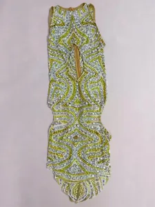Macro view of intricate yellow and silver rhinestone patterns on a mesh performance dress