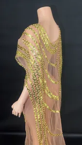 Detailed side view of mesh gown with elegant gold sequin waves and cape design