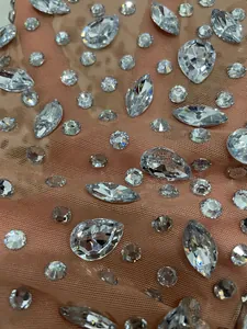 Primo piano di strass scintillanti su tessuto a rete color carne per abiti eleganti e sexy