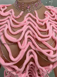 Detailed view of pink wavy textured performance bodysuit with sparkling rhinestone chains