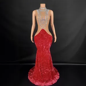 Elegant red velvet fishtail evening gown with rhinestone neck detail on mannequin
