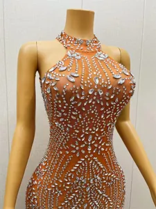 Gedetailleerd overzicht van sprankelende zilveren strass-patronen op een oranje mesh jurk