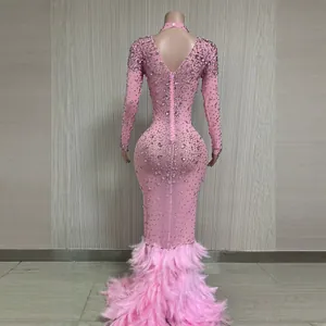 Elegante abito da sera rosa a maniche lunghe in rete con strass scintillanti e bordo in piume