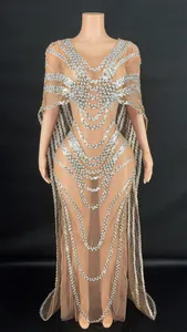 Detail view of a nude mesh evening gown with silver sequins and cape design.
